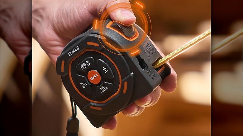 Pressing the blade lock button on a digital tape measure.