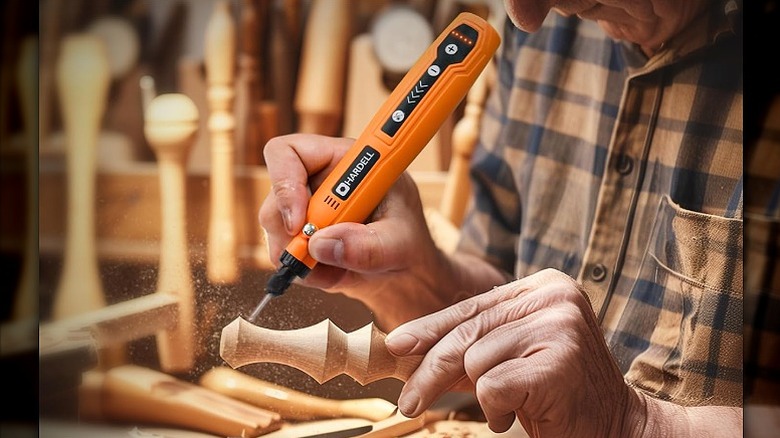 Using a rotary tool to carve a wooden object.