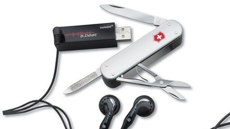 A white SwissBeat Swiss Army Knife with an integrated MP3 player and earbuds plugged in.