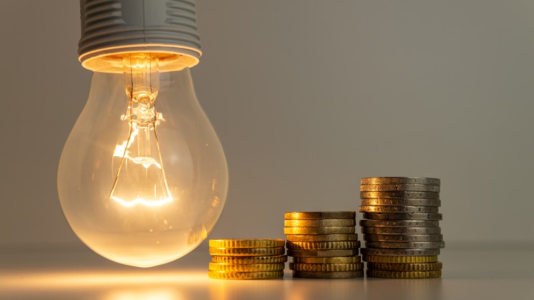 Lightbulb with stack of coins