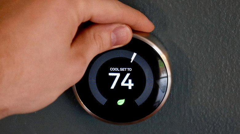 Hand adjusting a smart thermostat