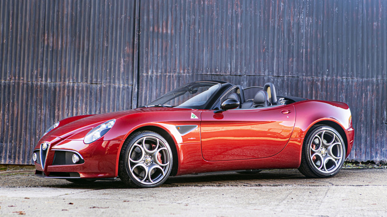 Red Alfa Romeo 8C Spyder parked on road.