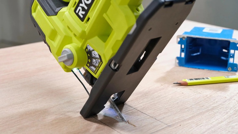 A worker making a plunge cut with Ryobi jig saw