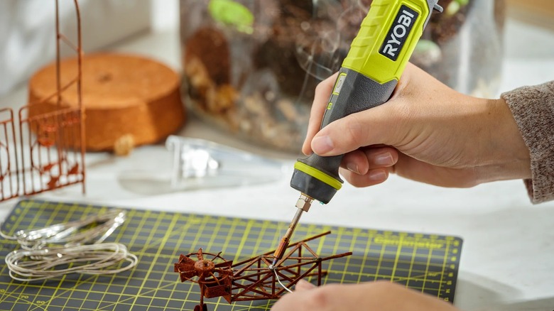 A person soldering delicate parts with Ryobi soldering pen