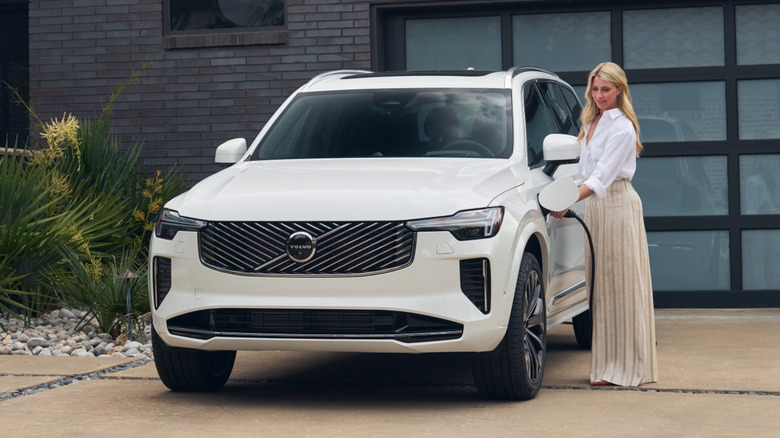Person standing next to a plug-in Volvo Hybrid