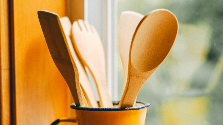 A few wooden spoons and forks in a cup.