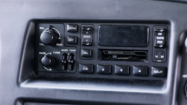 Close up of a car cassette player with various knobs and buttons