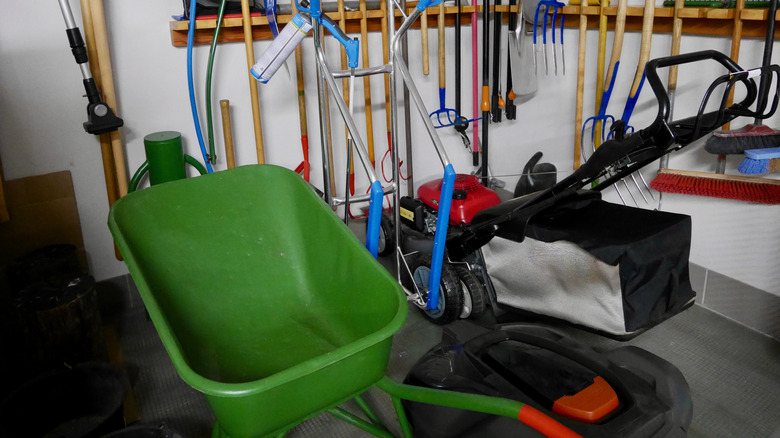 Garden tools and lawn mower in storage shed