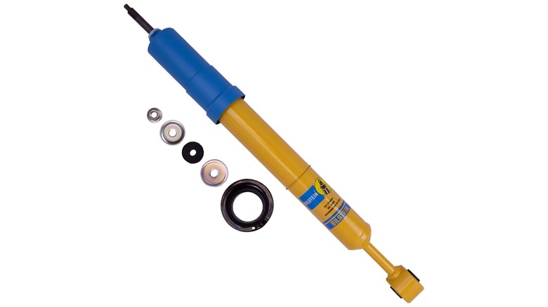 A blue and yellow Bilstein 4600 shock absorber sitting on a white background.