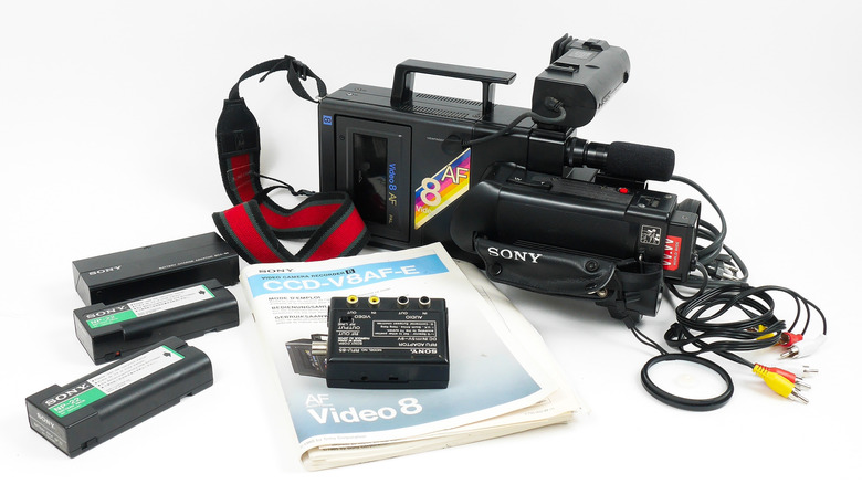 A man filming with a vintage camcorder.