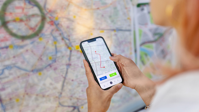 A smartphone map compared to a huge physical map.