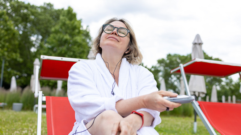 A woman enjoying music on a portable CD player.