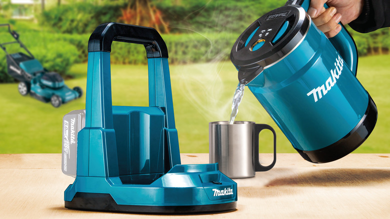 A person out of frame pouring water from a Makita 36V LXT Hot Water Kettle into a stainless steel cup.