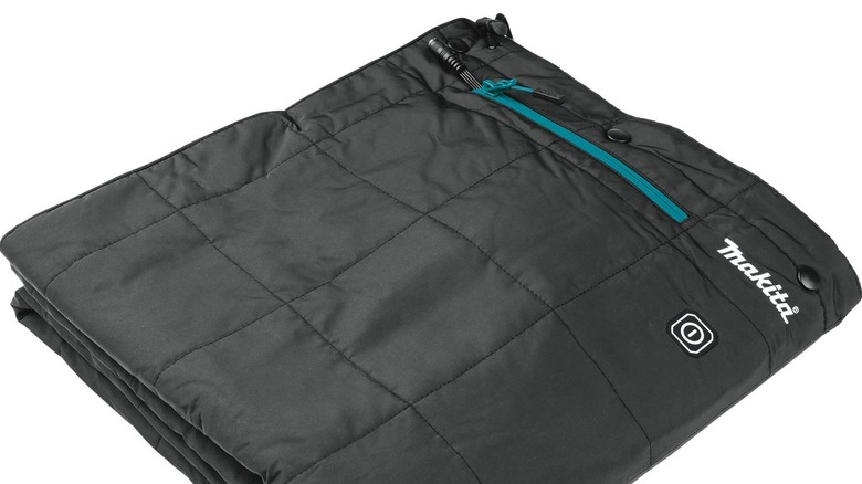A folded Makita cordless heated blanket with a teal zipper at the top.