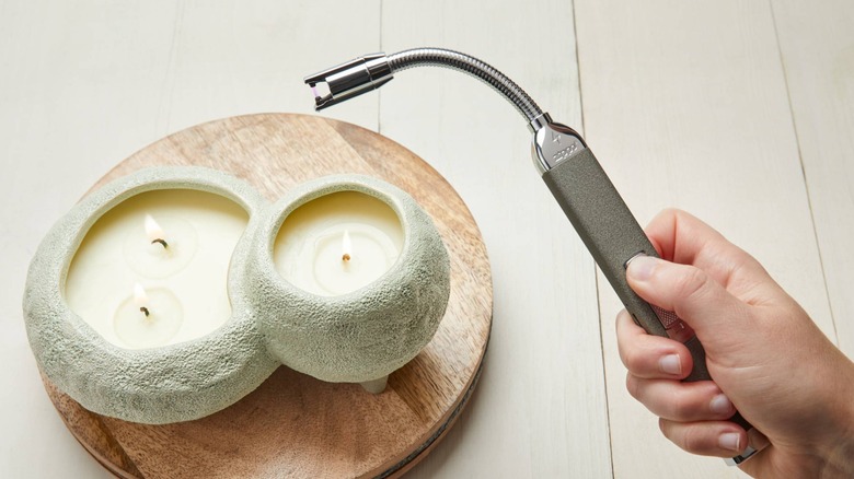 A Zippo rechargable candle lighter near some candles