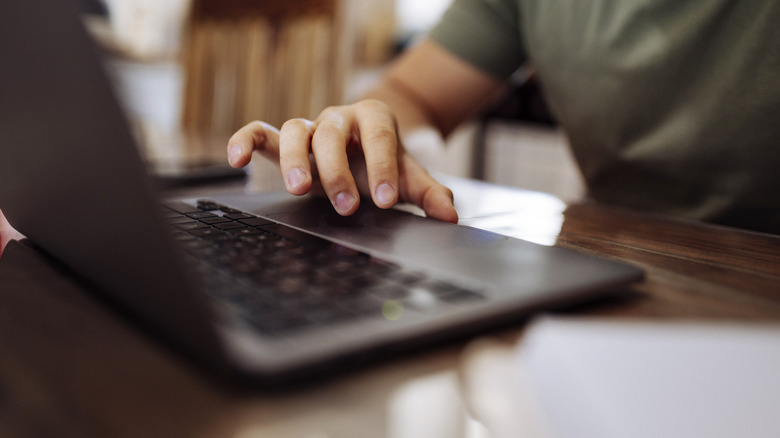 A person using a laptop at a table