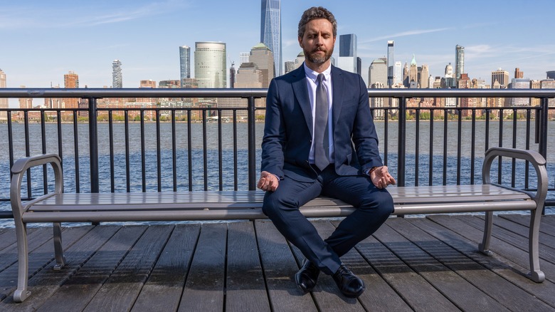 businessman meditating in public place outdoors