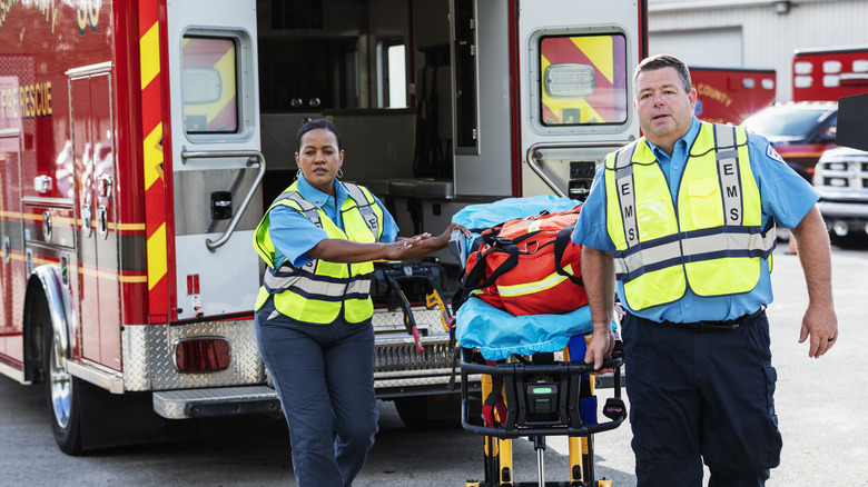 paramedics with gurney in front of ambulance