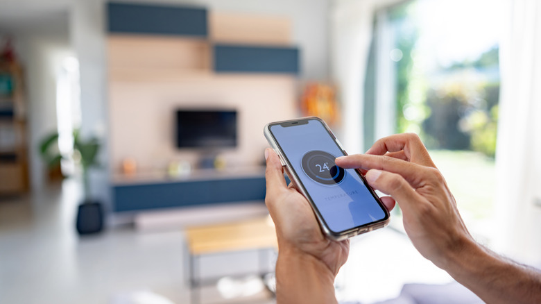 Person controlling a smart home app on their phone