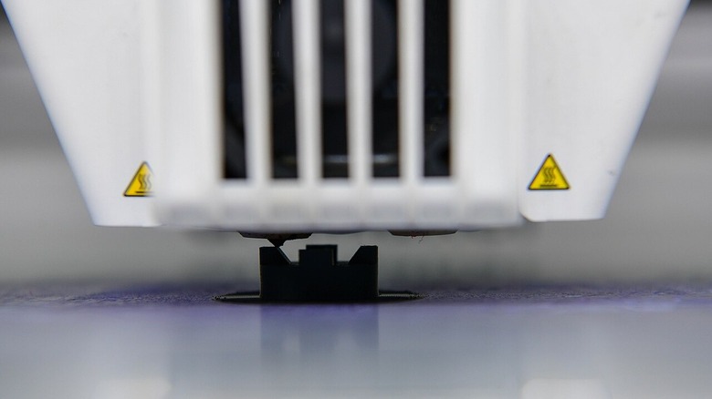Closeup of 3D printer printing a switch for an F-16