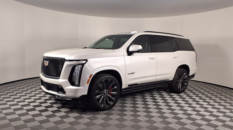 White Cadillac Escalade V on display against a white backdrop.