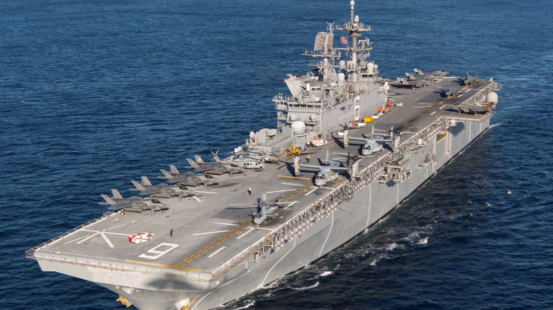 USS America (LHA-6) seen from high port side with helicopters, VM-22 Ospreys, and F-35Bs on deck