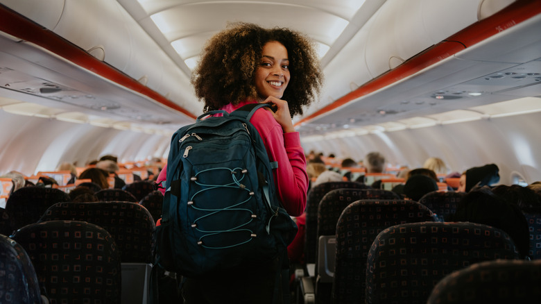 Passenger smiling in airplane aisle