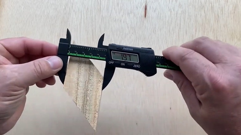 Person measuring wood with digital caliper