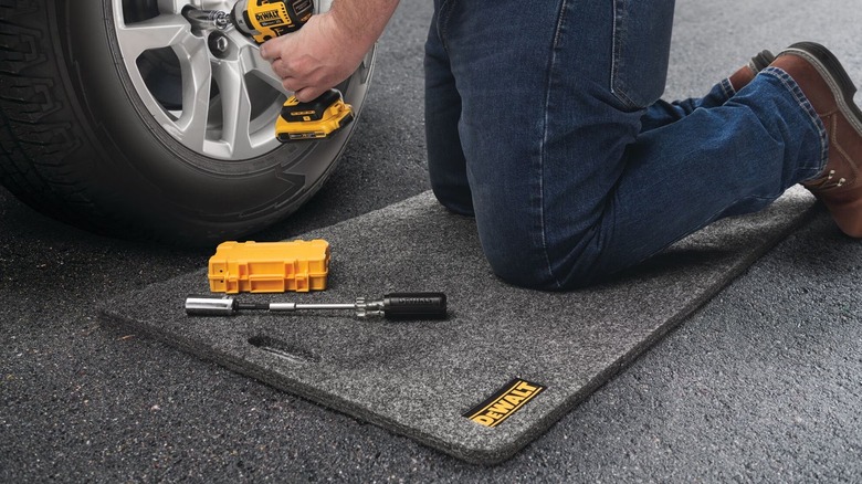 Person kneeling on DeWalt utility mat