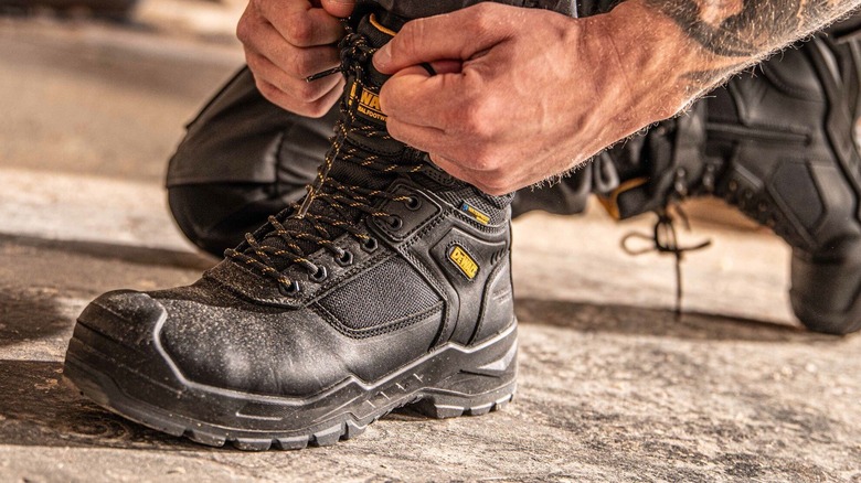 Person tying DeWalt work boots