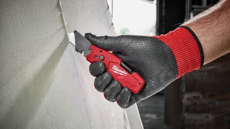 cutting drywall sheet with Milwaukee knife