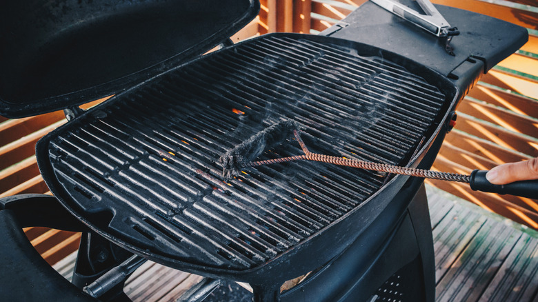 Person cleaning barbecue grill