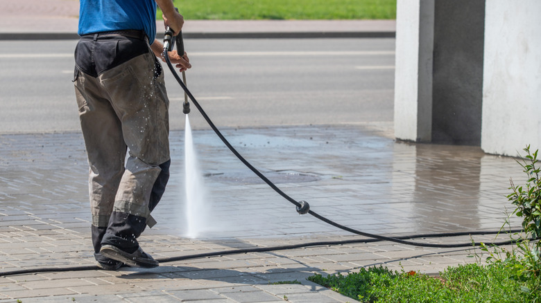 Person pressure washing the concrete