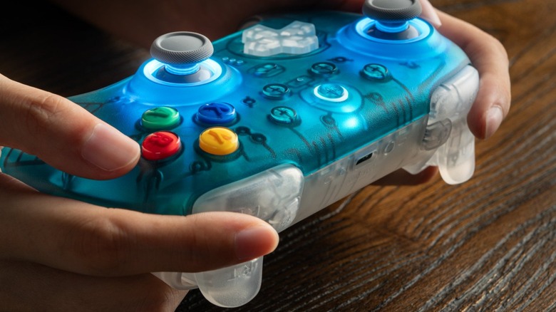Hands holding the N64 30th Collection ClearBlue of 8BitDo Ultimate 2 Wireless Controller.