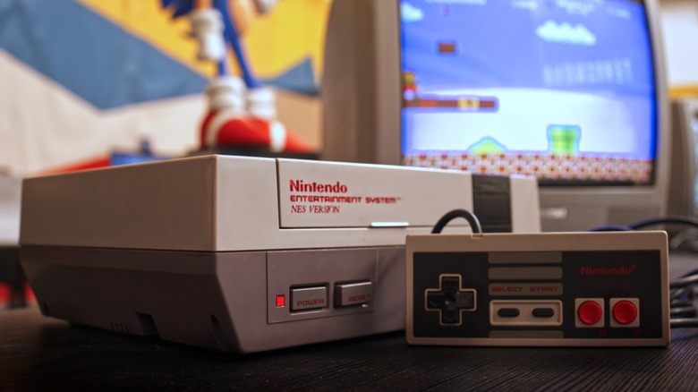 A Nintendo Entertainment System console on a desk with a CRT TV in the background.