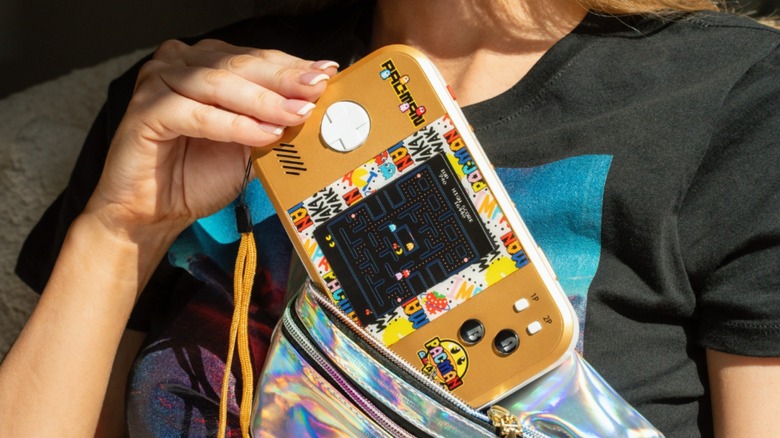 The Pac-Man Pocket Player Max being inserted into a bag.