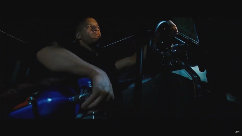 Vin Diesel's character, Dominic Toretto, unscrewing a bottle of nitrous oxide inside his car in a 2009 film.