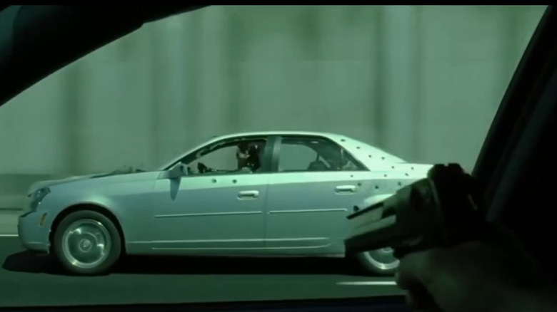 A gun being pointed at a silver Cadillac CTS as part of a scene from "The Matrix Reloaded" from 2003.