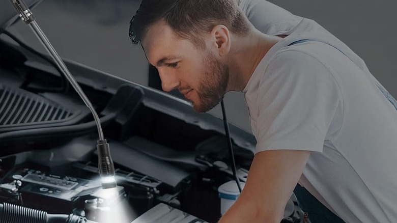A person using a Biib extendable magnetic pick-up tool when looking at a car's engine bay