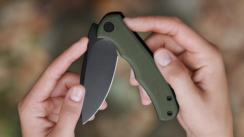 A person folding a Civivi mini pocket folding knife