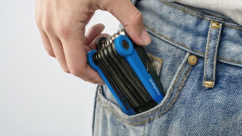 A person putting a Kraftek folding allen key set inside their pocket