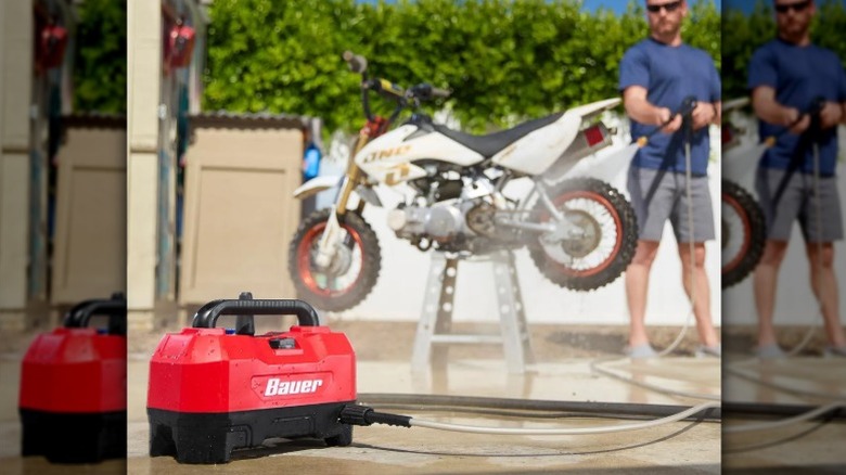 Bauer pressure washer with a person washing a motorbike in the background