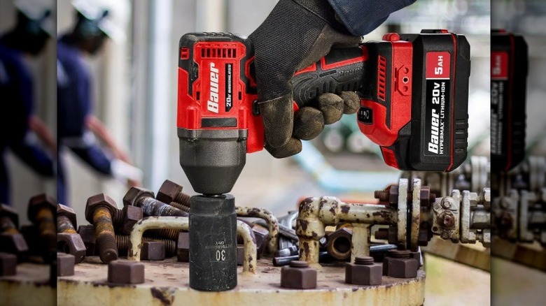 Close-up of a hand using a Bauer impact wrench to tighten nuts