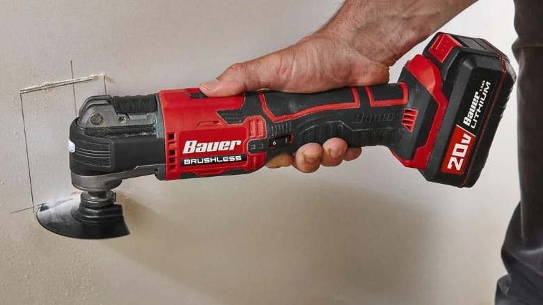 Person cutting drywall with a Bauer oscillating multi-tool