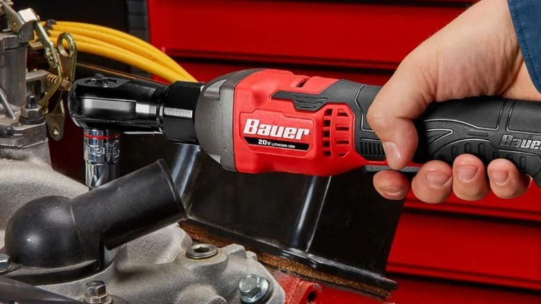 Close-up of a person using a Bauer cordless ratchet on an engine