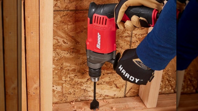 Person using a Bauer hammer drill on wood