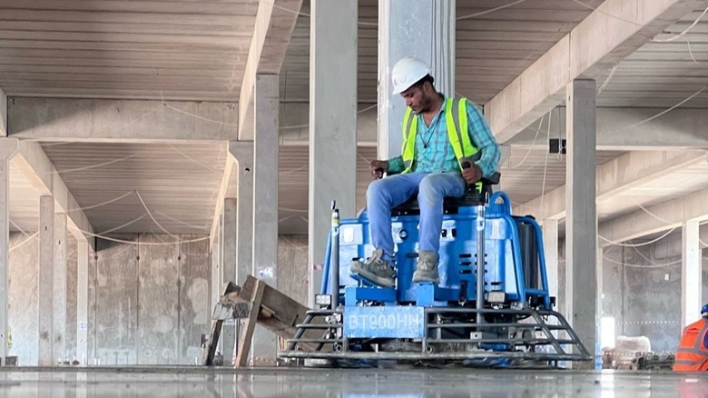 Person using ride on power trowel