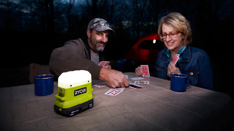 Couple plays card with the Ryobi ONE+ 18V Compact Area Light