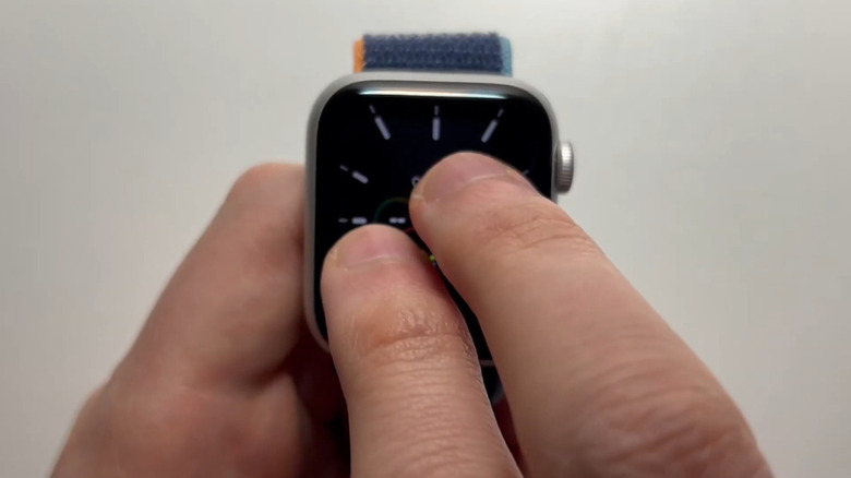 A person double-tapping their Apple Watch to tell the time