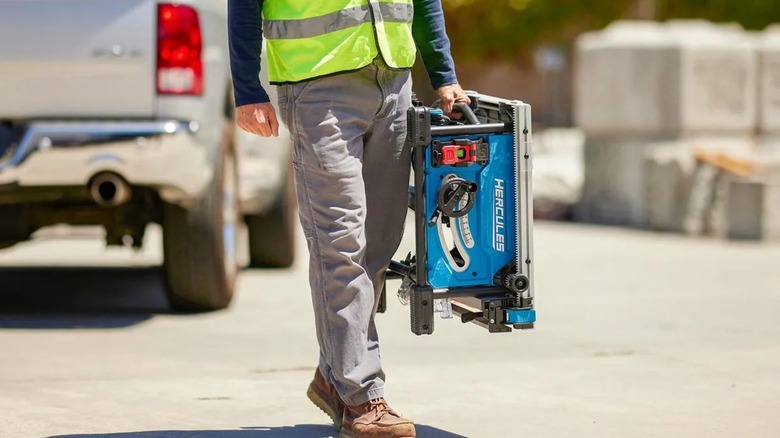 worker carrying Hercules table saw with one hand